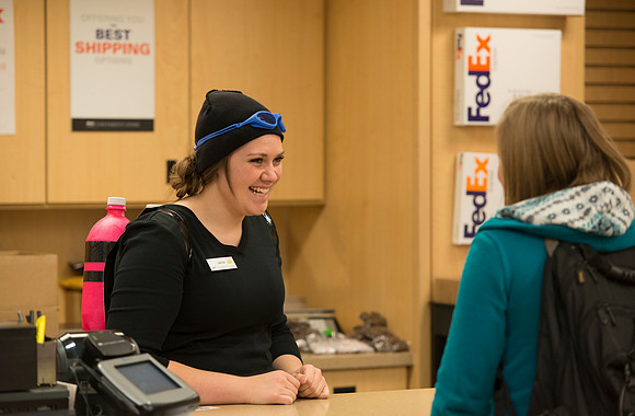 An employee of Express Print and Copy, dressed up for Halloween, helps a customer.