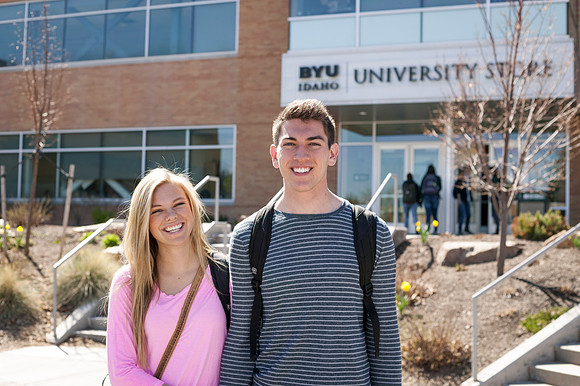 A newly engaged couple happily smiles as they are welcomed back to school with beautiful weather.