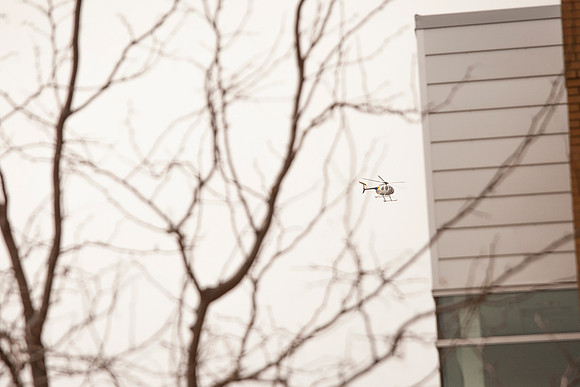 A helicopter flys over the Ricks Building during Finals week.