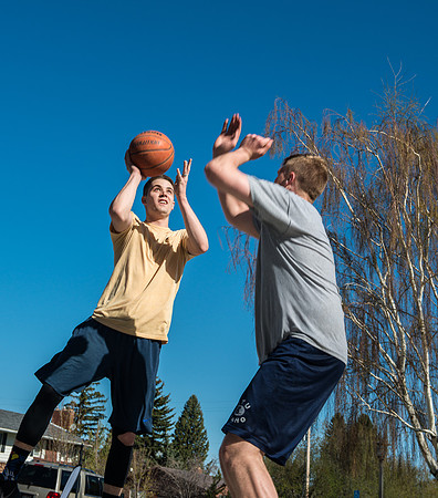 Jacob Kaiser (in yellow) playing basketball, one on one with Jacob Madsen at Smith Park in Rexburg, Idaho.