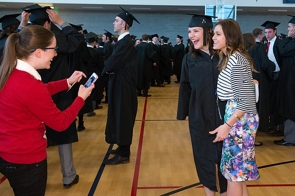 A student poses with a friend before processional. Photo by Ryan Chase