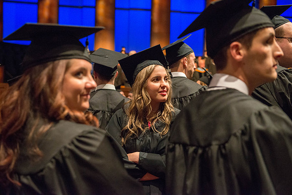 Graduates show their appreciation to the faculty and their families during the commencenment ceremony. Photo by Ryan Chase