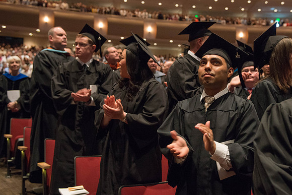 Graduates show their appreciation to the faculty and their families during the commencenment ceremony. Photo by Ryan Chase