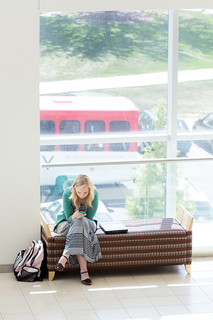 A student waits for devotional to begin in the stairwell leading to the Balcony of the I-Center.