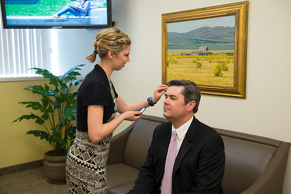 Behind the scenes of devotional, the speaker, Drew Eader, gets a little powder to reduce the shine from the bright lights.
