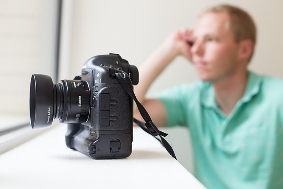 University Photographer Tyler Rickenbach ponders the universe with his Canon 1Ds camera in the foreground.