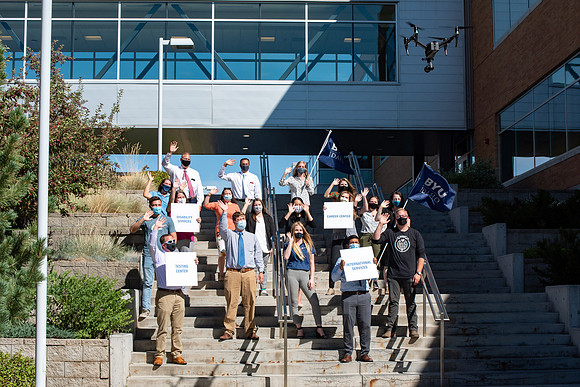 Drone shots of faculty groups around campus say "We're in this together."