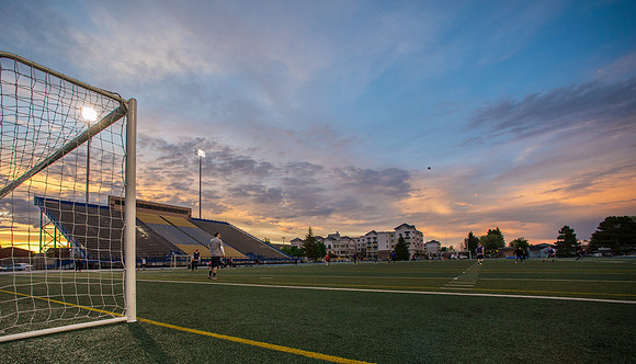 The sun sets beautifully after some rain during a soccer game at the BYU-Idaho Stadium.