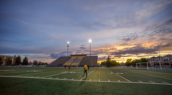 The sun sets beautifully after some rain during a soccer game at the BYU-Idaho Stadium.