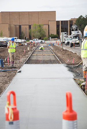 Workers prepare the ground for asphalt and concrete, which will form a new parking lot near the Snow building.