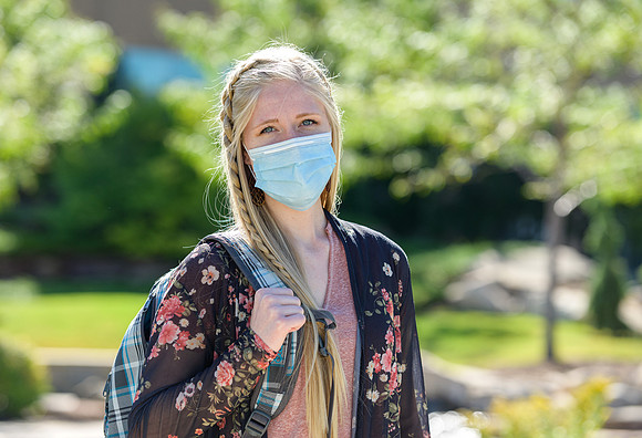 Student volunteers show the way to stay safe during this COVID 19 pandemic by social distancing, following pathway arrows and proper wearing of masks .