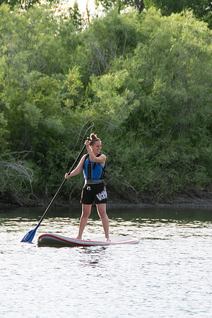 Students of Brigham Young University-Idaho go standup paddle boarding on the river at Warm Slough.