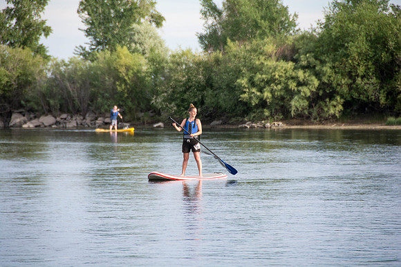 Students of Brigham Young University-Idaho go standup paddle boarding on the river at Warm Slough.