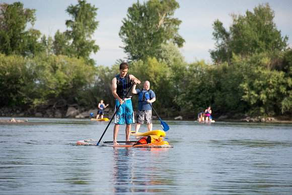 Students of Brigham Young University-Idaho go standup paddle boarding on the river at Warm Slough.