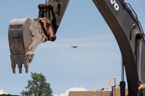 A drone watches the workers prepare for the blasting.