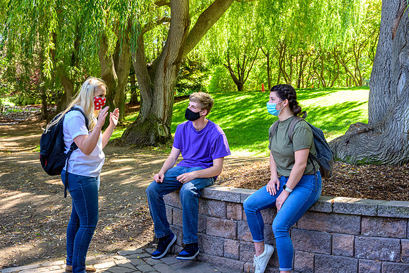 Student volunteers show the way to stay safe during this COVID 19 pandemic by social distancing, following pathway arrows and proper wearing of masks .