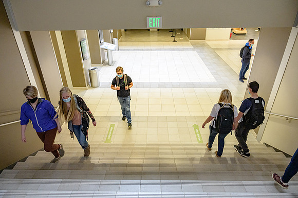 Student volunteers show the way to stay safe during this COVID 19 pandemic by social distancing, following pathway arrows and proper wearing of masks .
