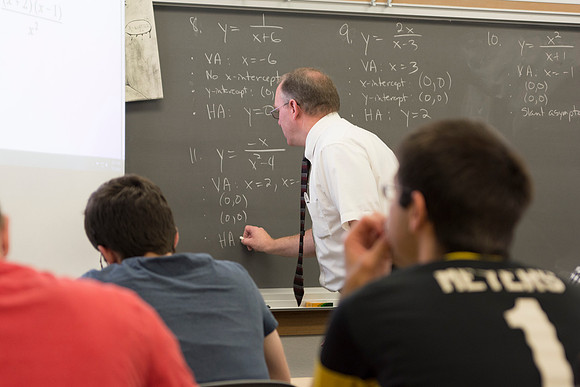 Brother Johanson writes a problem on the chalkboard for his Math 109 Precalculus to solve during the 2014 Spring Semester.