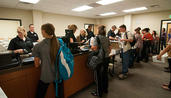 New students purchasing textbooks a few days before school starts. Students have the ability to pre-order books online which are then packaged and stored until they are picked up.