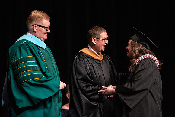 Graduates receive their diplomas during Performing and Visual Arts convocation.