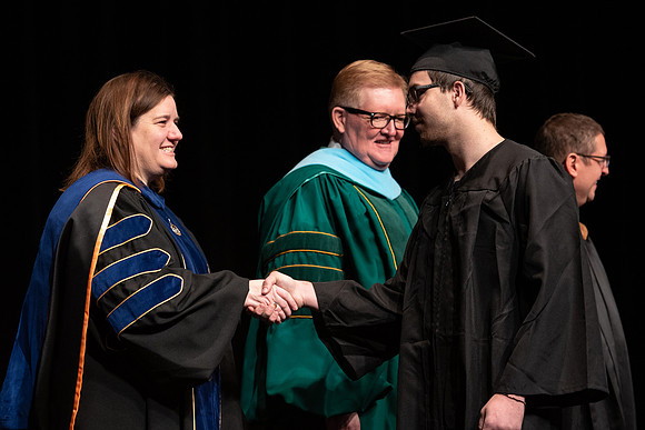 Graduates receive their diplomas during Performing and Visual Arts convocation.