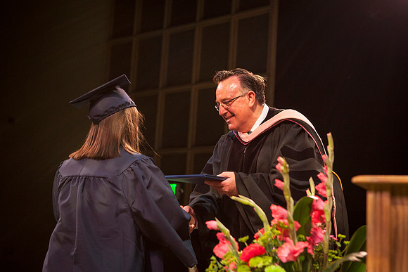 Jon Linford shakes hands with graduates as they are handed their diplomas during Convocation held in the Kirkham Building. Photo by Tyler Rickenbach