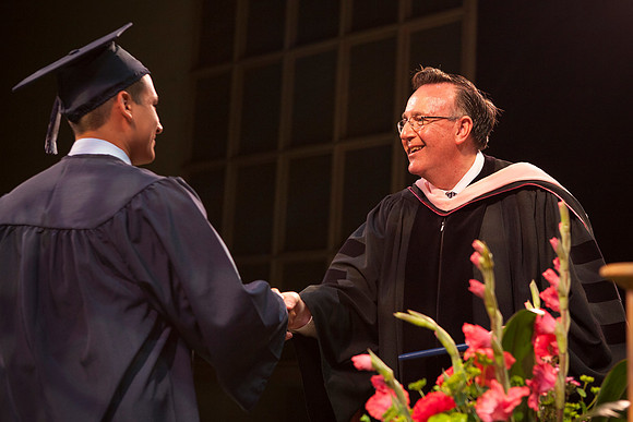 Jon Linford shakes hands with graduates as they are handed their diplomas during Convocation held in the Kirkham Building. Photo by Tyler Rickenbach