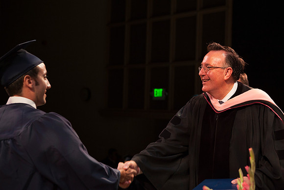 Jon Linford shakes hands with graduates as they are handed their diplomas during Convocation held in the Kirkham Building. Photo by Tyler Rickenbach