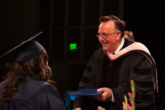 Jon Linford shakes hands with graduates as they are handed their diplomas during Convocation held in the Kirkham Building. Photo by Tyler Rickenbach
