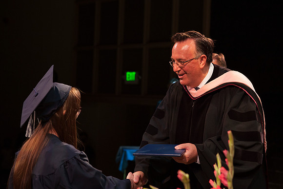 Jon Linford shakes hands with graduates as they are handed their diplomas during Convocation held in the Kirkham Building. Photo by Tyler Rickenbach