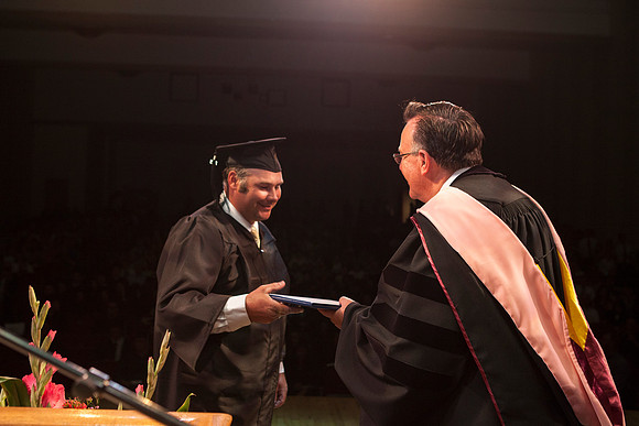 Jon Linford shakes hands with graduates as they are handed their diplomas during Convocation held in the Kirkham Building. Photo by Tyler Rickenbach