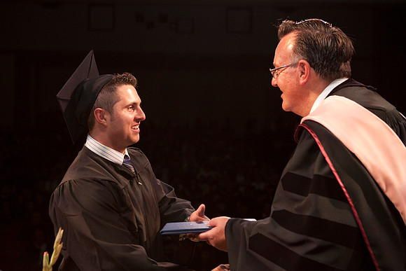 Jon Linford shakes hands with graduates as they are handed their diplomas during Convocation held in the Kirkham Building. Photo by Tyler Rickenbach