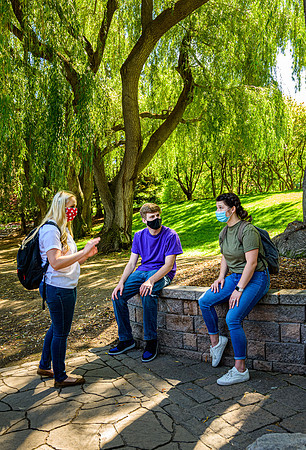 Student volunteers show the way to stay safe during this COVID 19 pandemic by social distancing, following pathway arrows and proper wearing of masks .