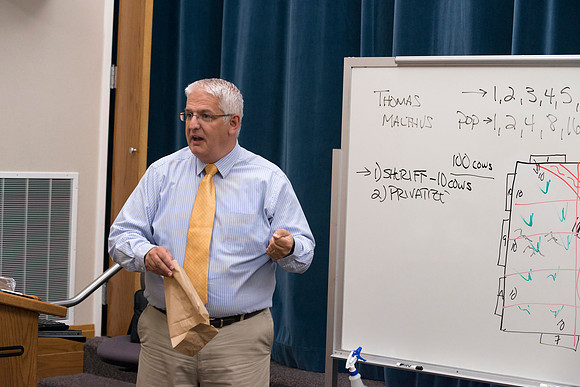 Brother Duane Adamson explains to his Political Science class a game they will play during class.