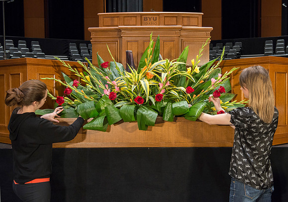 Floral Design students, Lauren Smith and Margaret Setterstrom create a beautiful floral arrangement in front of the podium for devotional.