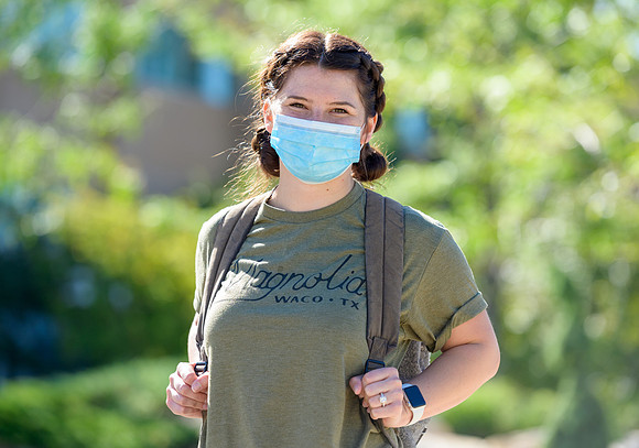 Student volunteers show the way to stay safe during this COVID 19 pandemic by social distancing, following pathway arrows and proper wearing of masks .
