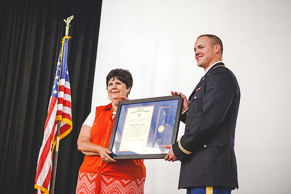 Janine Clifford gives 2LT Plummer his plaque during the Comissioning Ceremony.