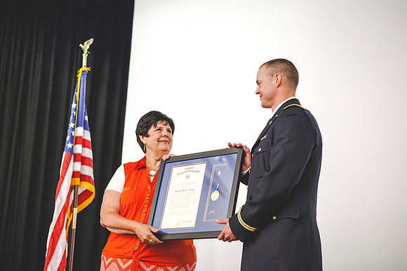 Janine Clifford gives 2LT Plummer his plaque during the Comissioning Ceremony.