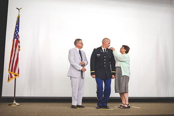 2LT John R. Flanigan get his rank pinned onto his uniform from Tim and Katie Flanigan during the BYU-Idaho ROTC Comissioning Ceremony.