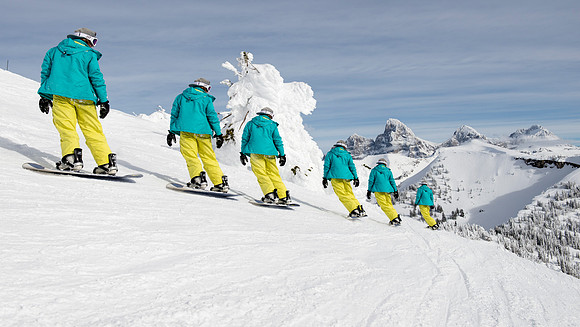 BYU-Idaho students taking a snowboarding class, snowboard with the Tetons in the background.