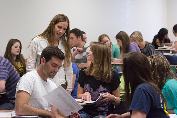 A student in Sister Christensen's Essentials of Human Nutrition class points a porition in the textbook concerning their group assignment.