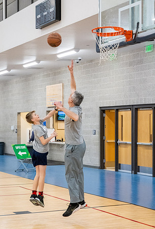 A father and son playing basketball in the I-Center courts.