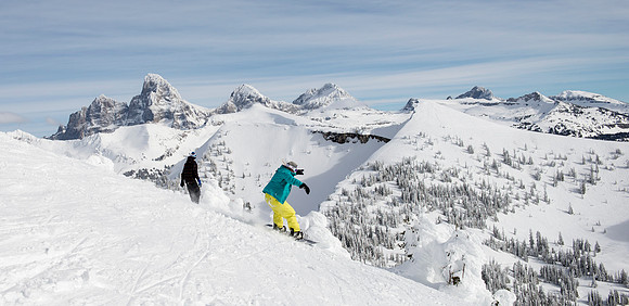 BYU-Idaho students taking a snowboarding class, snowboard with the Tetons in the background.