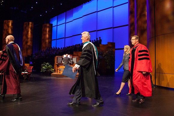 Elder Dallin H. Oaks, Elder Dieter F. Uchtdorf, and President Clark G. Gilbert with his wife Christine, walk across the ICenter stage as the Inauguration begins.