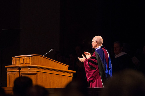 Elder Dallin H. Oaks applauds after President Gilbert's remarks.