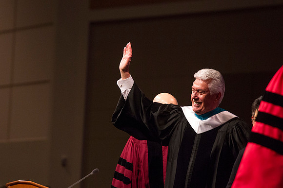 President Dieter F. Uchtdorf waves goodbye as he walks off stage.