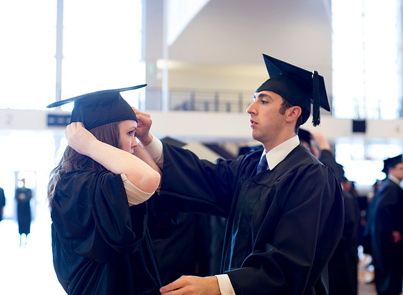 Graduates wait inside the gym area preparing to enter Commencement ceremony.