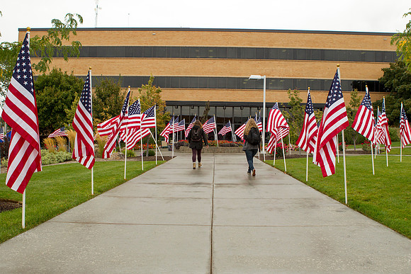 Students walk past the American Flags on display in the quad.