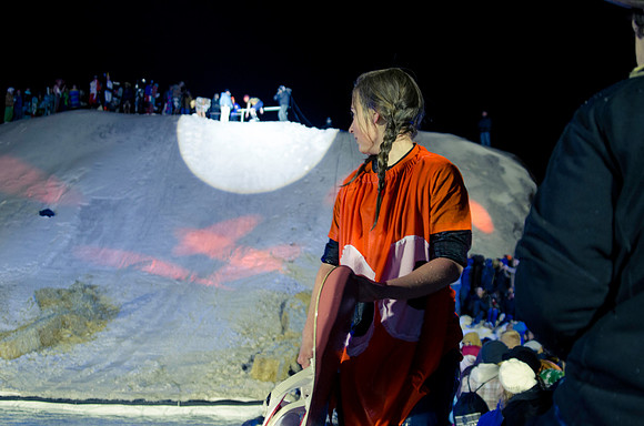 A pond skimming participant watches as fellow contestants get ready to launch across the water.