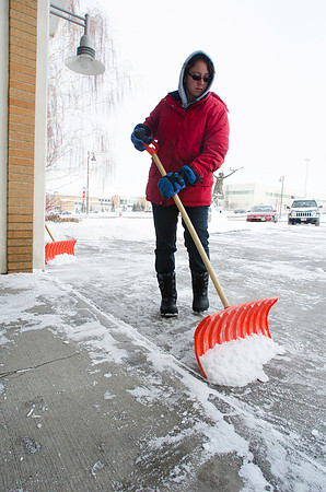 A student shovels walkways free of fresh fallen snow.